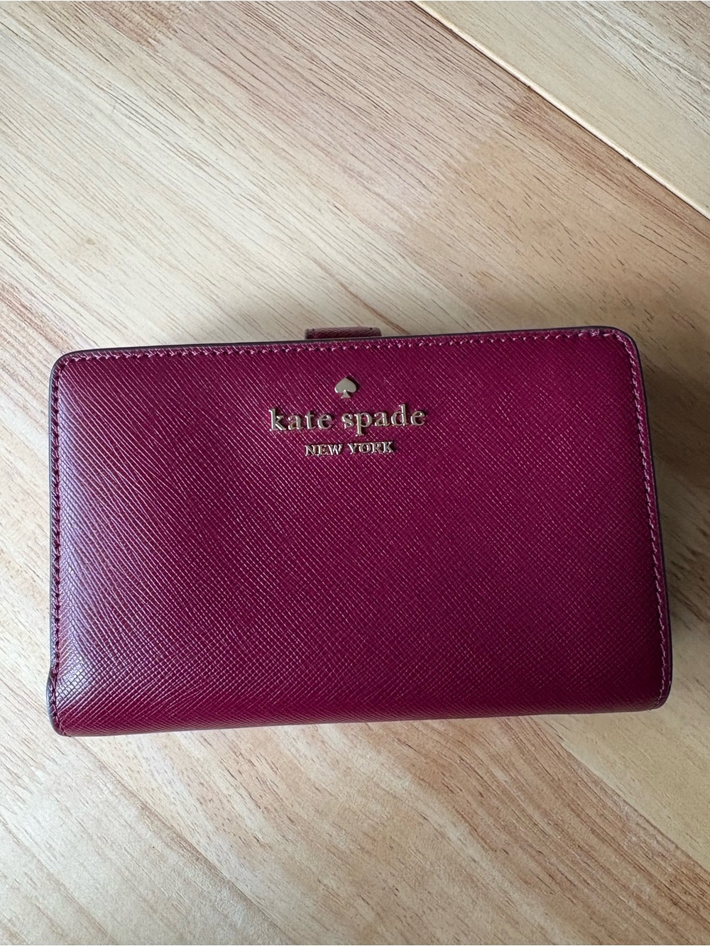 kate spade burgundy leather zip-around wallet with gold logo
